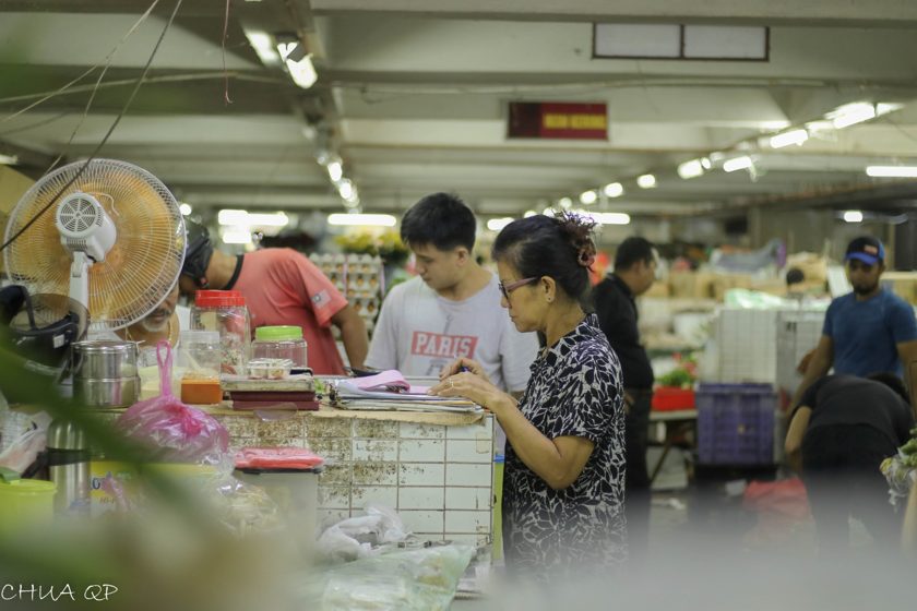 People choosing items at an indoor market stall