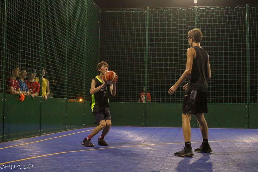Basketball players preparing a play on a floodlit court