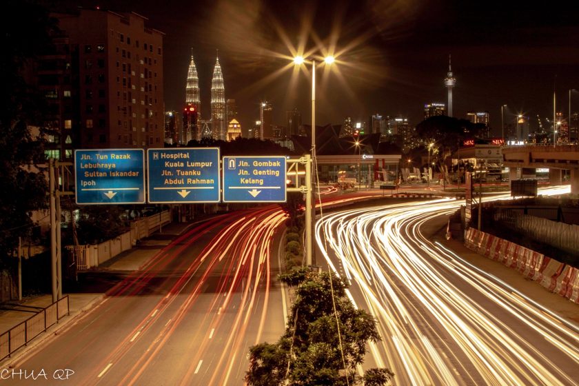 Long-exposure traffic light trails along a city highway at night