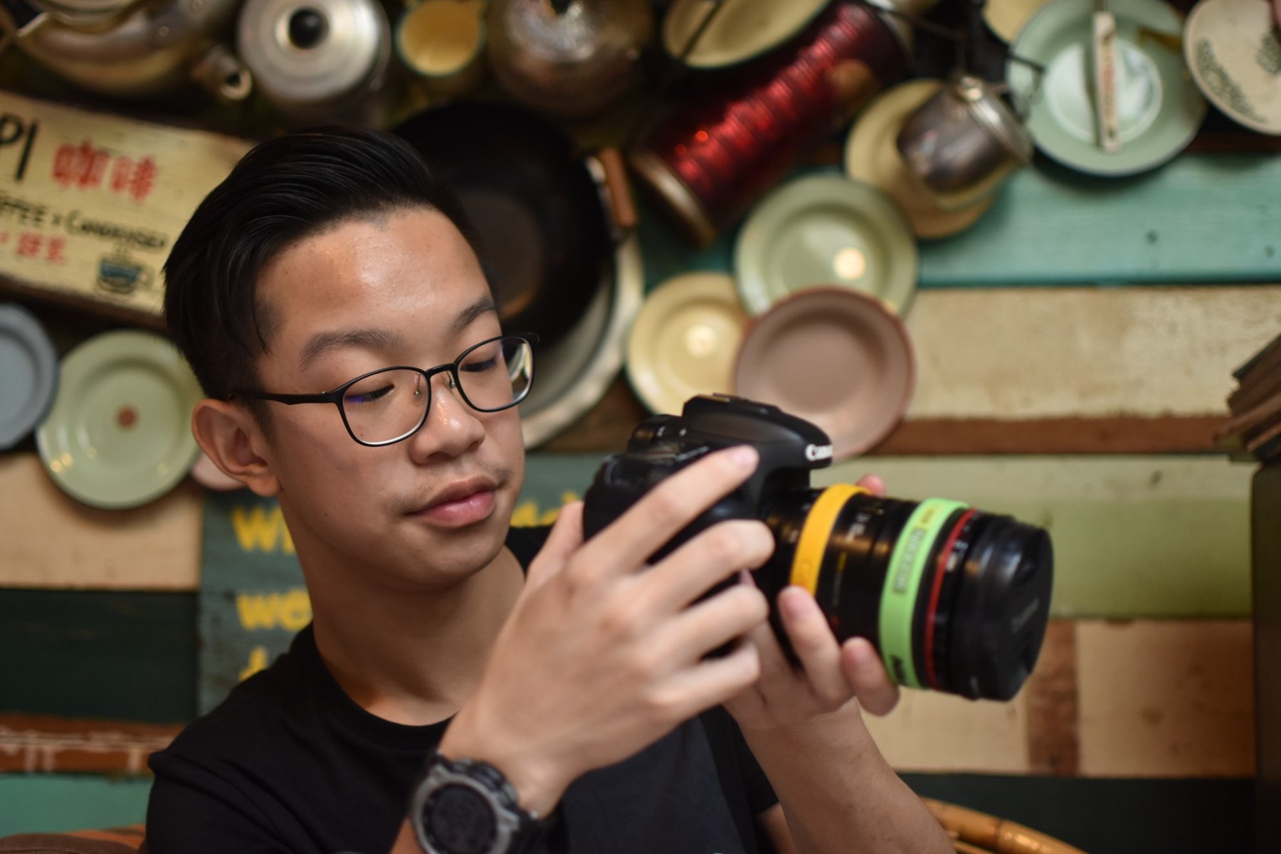 Chua Qin Peng holding a Canon camera