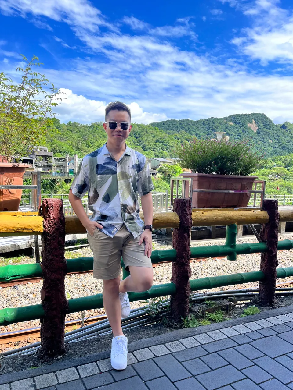 Chua Qin Peng outdoors with green hills and blue skies